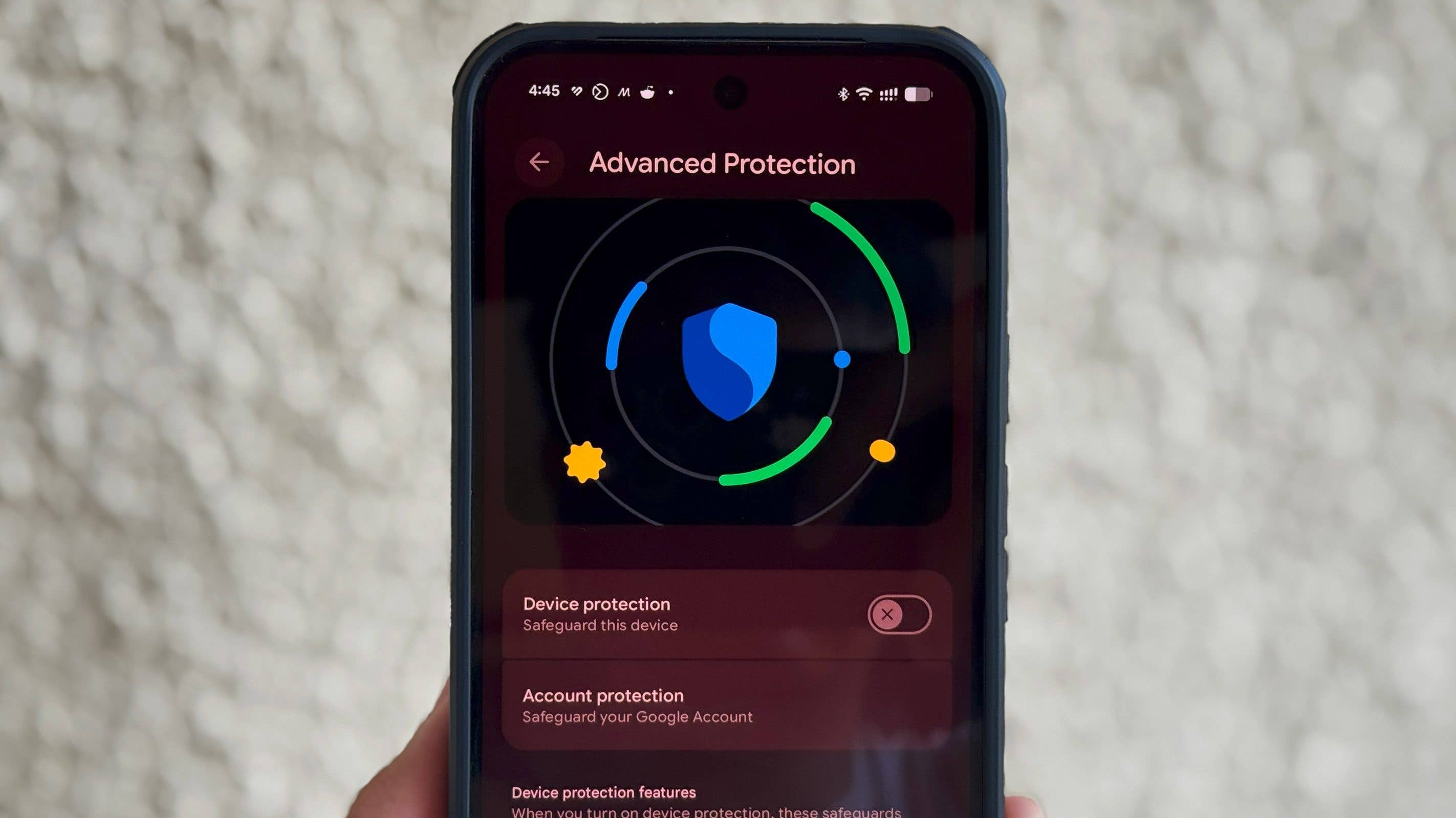 Un smartphone affiche les paramètres de 'Protection Avancée' avec des icônes de sécurité et des options pour la protection des appareils et des comptes.