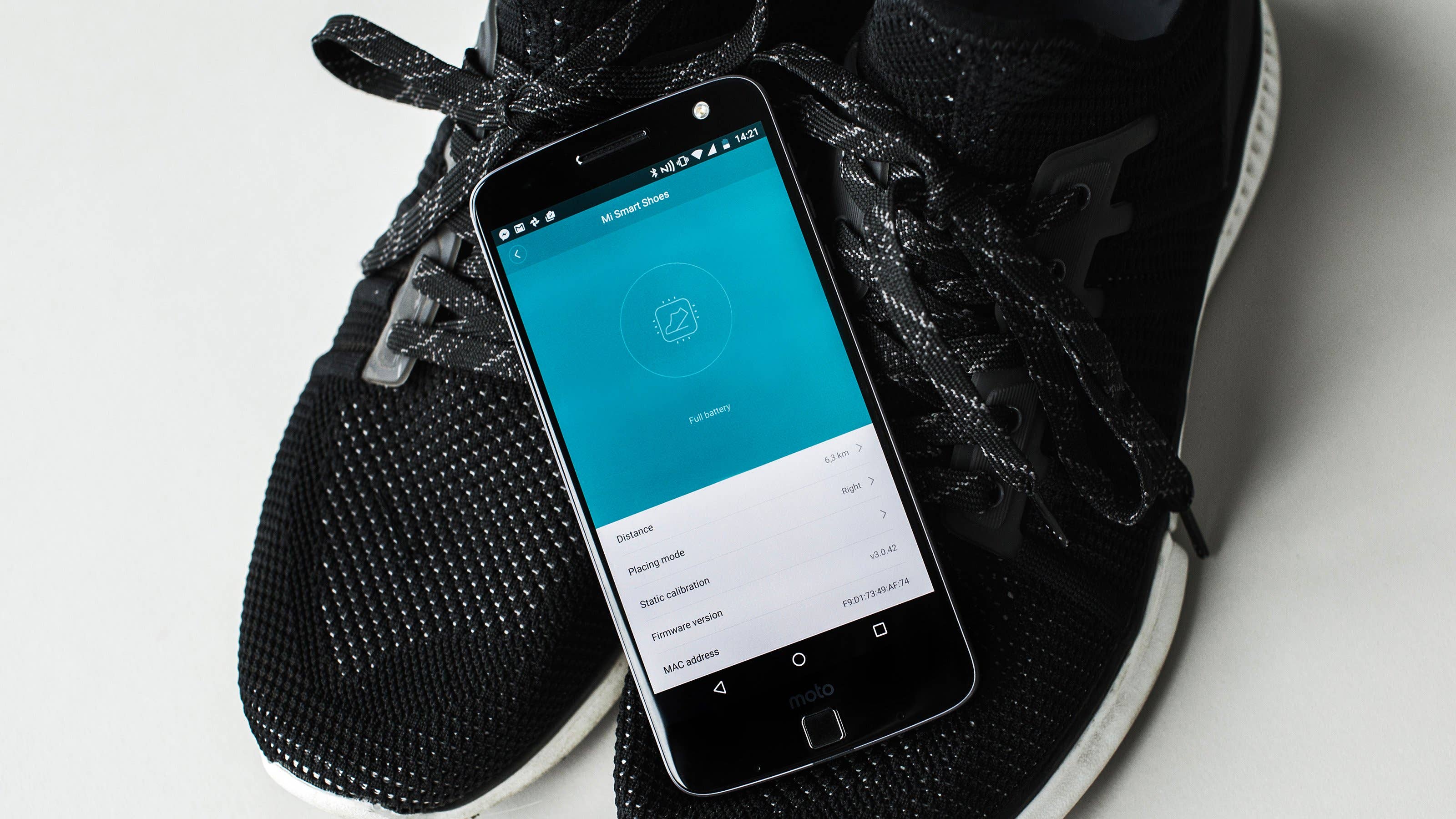 Chaussures intelligentes Xiaomi avec un smartphone affichant l'application Mi Smart Shoes.