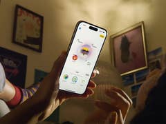 Une personne tenant un iPhone affichant une interface d'application colorée dans une pièce confortable.