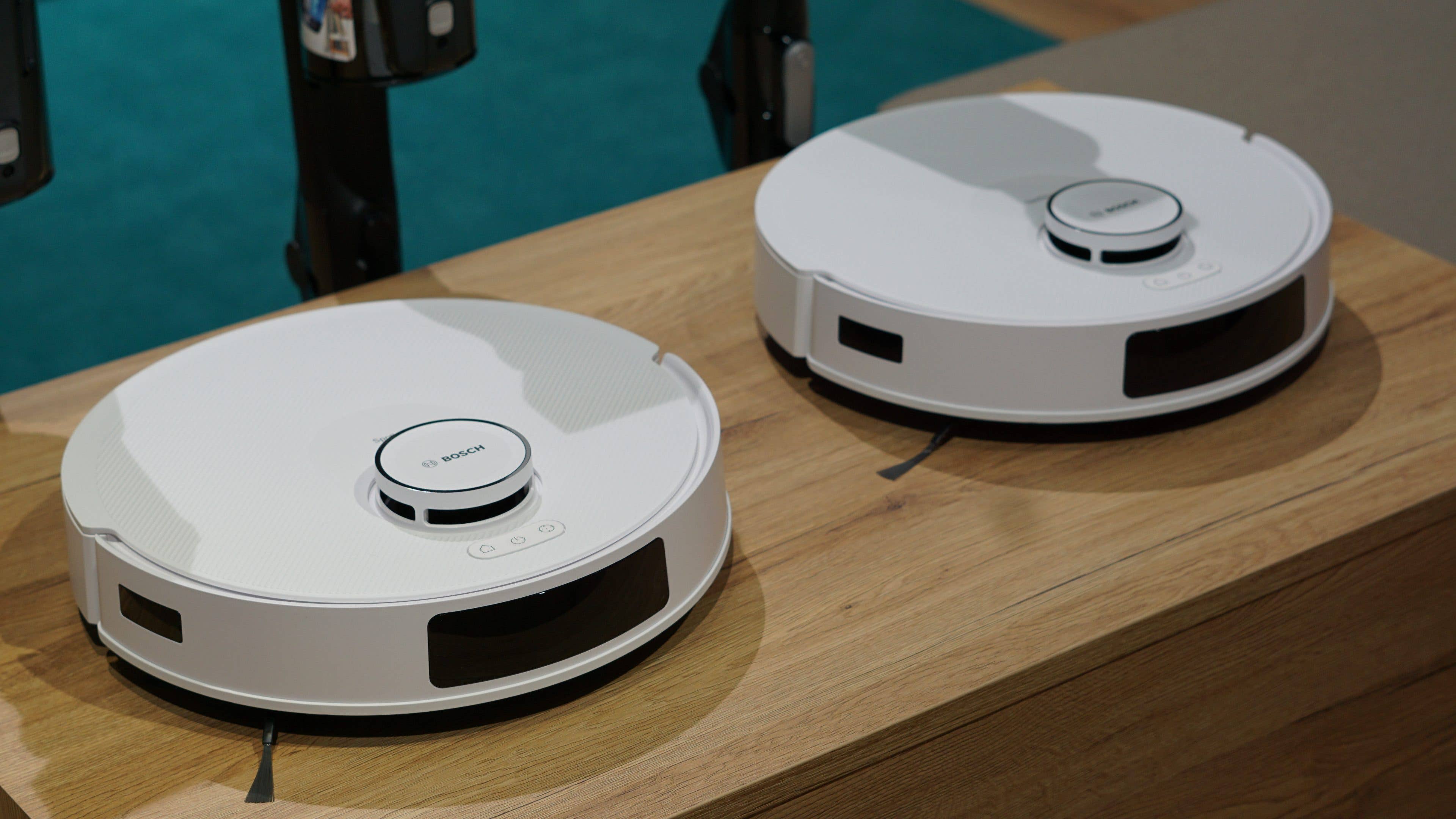 Deux aspirateurs robots Bosch Spotless sur une surface en bois.