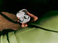 Écouteurs Bose QuietComfort en blanc sur un fond vert clair.