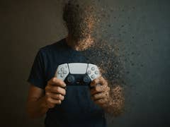 Une personne tient une manette PlayStation, se transformant en poussière, symbolisant le message 'stop killing games'.