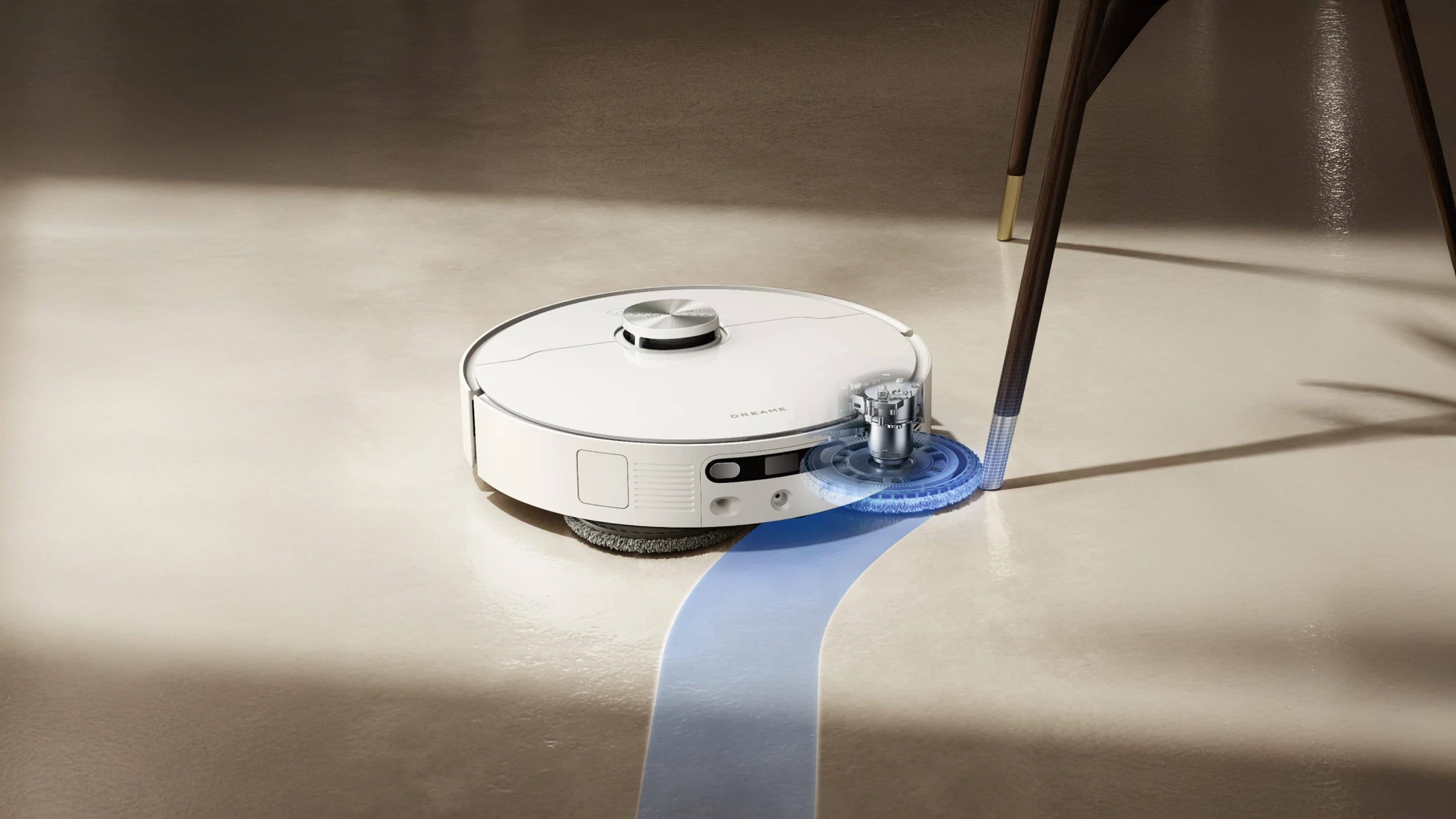 Un aspirateur robot Dreame L40 Ultra AE nettoyant un sol sous une table.