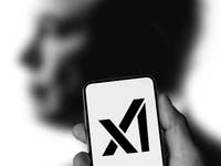 Une main tenant un smartphone affichant le logo 'X' devant une silhouette humaine floue.