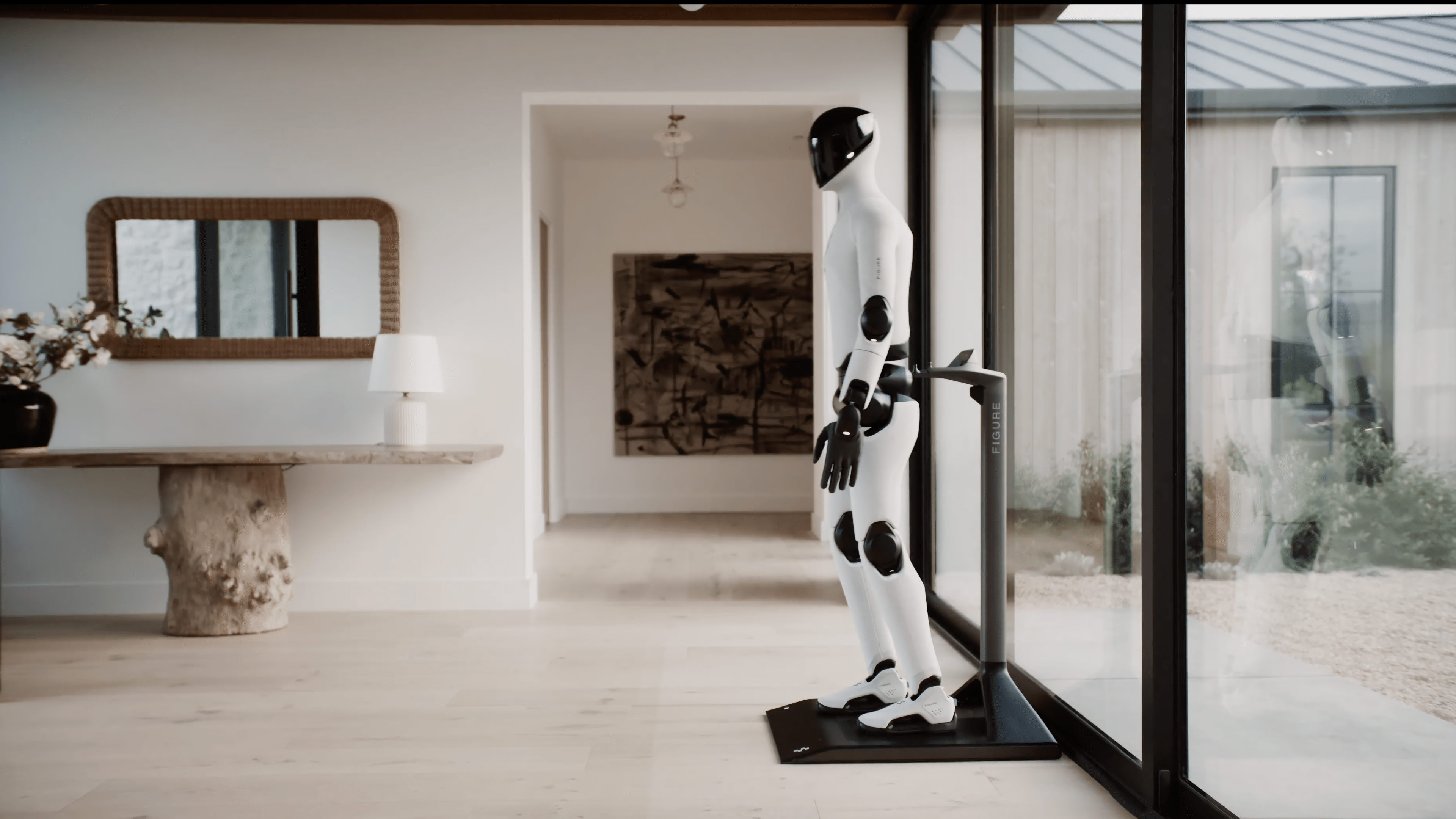 Un robot humanoide se encuentra en un interior moderno junto a una mesa y una gran ventana.