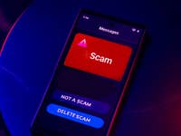 Un écran de smartphone affichant un message étiqueté 'Arnaque' avec les options 'Pas une arnaque' et 'Supprimer l'arnaque'.