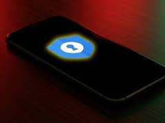 Un smartphone affiche le logo de Google Password Manager sur un fond sombre.