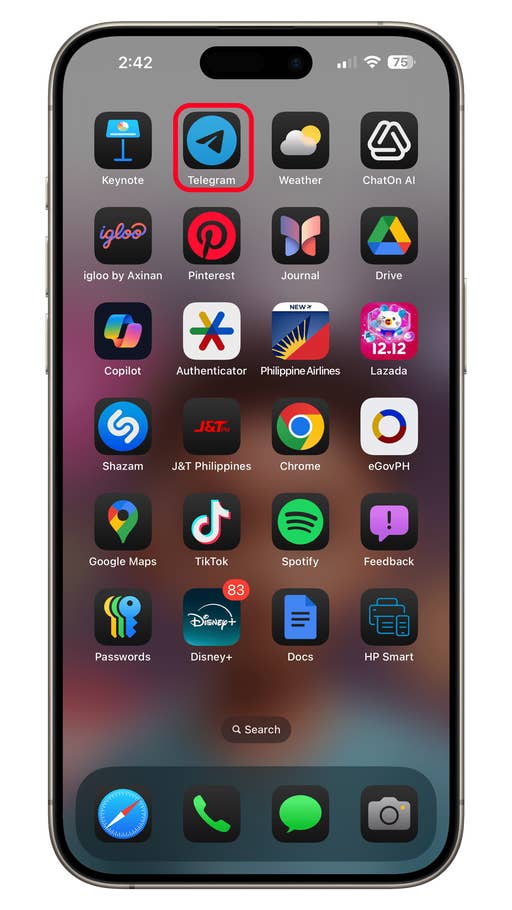 Écran du0027accueil iOS 18 avec divers icônes du0027applications, y compris Telegram, Spotify et Disney+.
