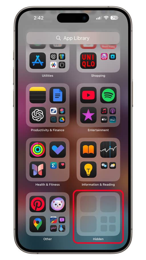 iPhone affichant la bibliothèque du0027applications dans iOS 18 avec divers dossiers du0027applications et un dossier u0027Cachéu0027 en surbrillance.