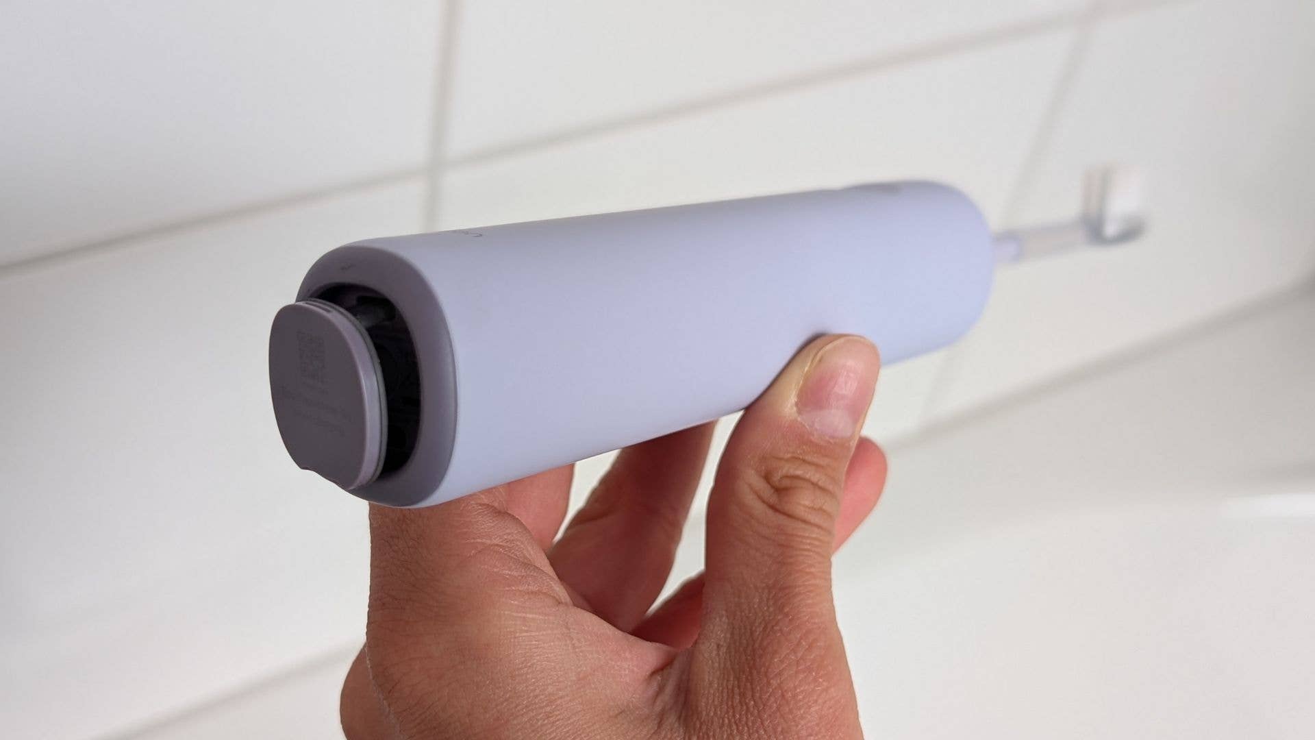 Une personne tenant un connecteur de charge spécial Laifen Wave.