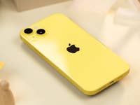 iPhone 14 jaune posé à plat sur une table et vu de dos