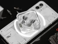 Les Nothing ear (2) dans leur boîtier posés sur l'arrière du Nothing Phone (1)