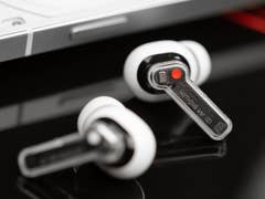 Les Nothing ear (2) posés à plat sur une table avec un aperçu de leurs tiges transparentes