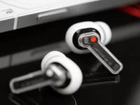 Les Nothing ear (2) posés à plat sur une table avec un aperçu de leurs tiges transparentes