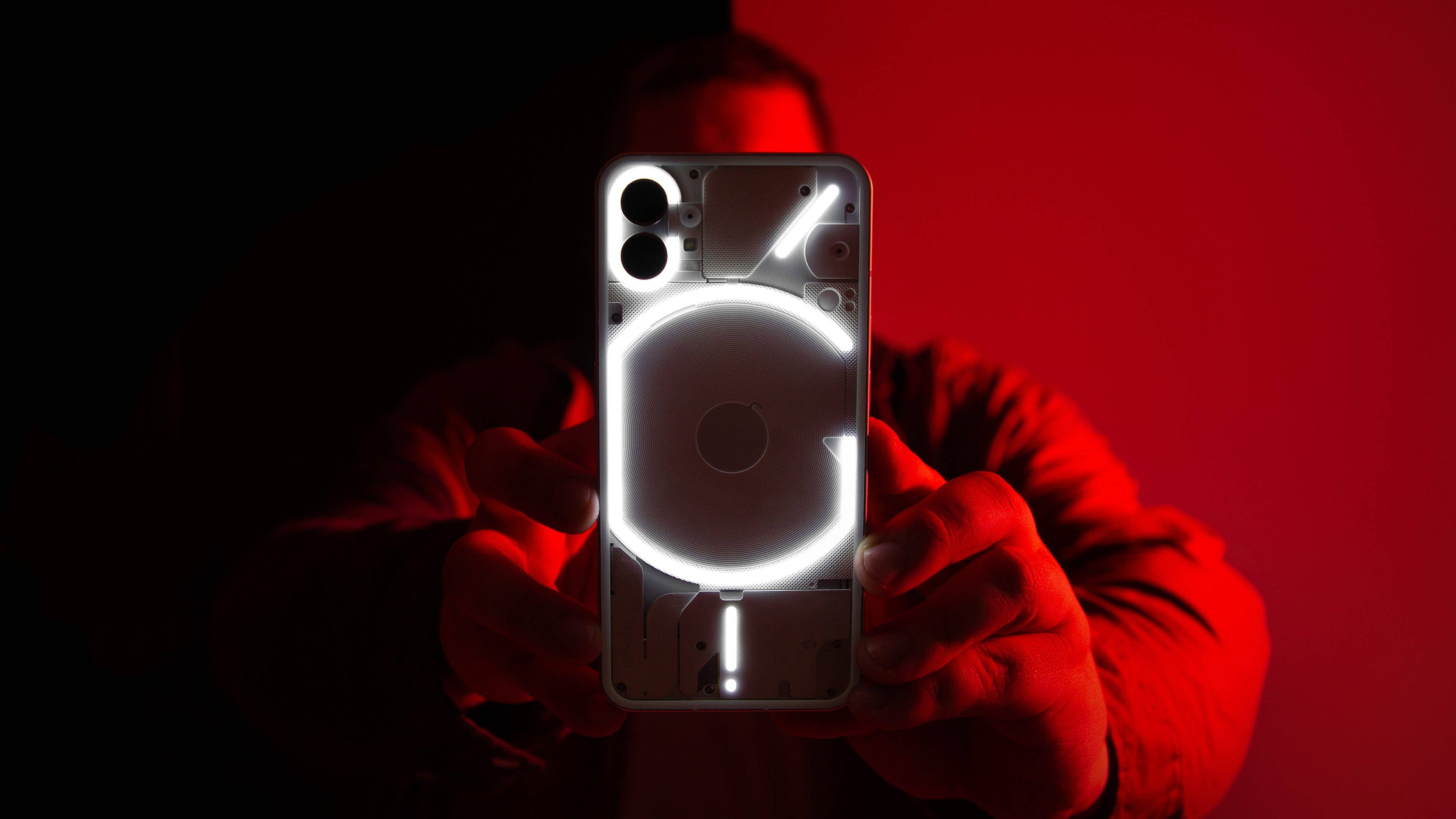 Nothing Phone 1 image de Une avec Antoine qui tient le telephone sur un fond rouge et noir