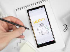 Galaxy S23 Ultra design vu de face avec une main tenant le S Pen à la gauche du smartphone posé à plat