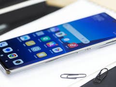 Le Xiaomi 13 Pro posé à plat sur le dos sur un carnet blanc avec son écran Amoled visible