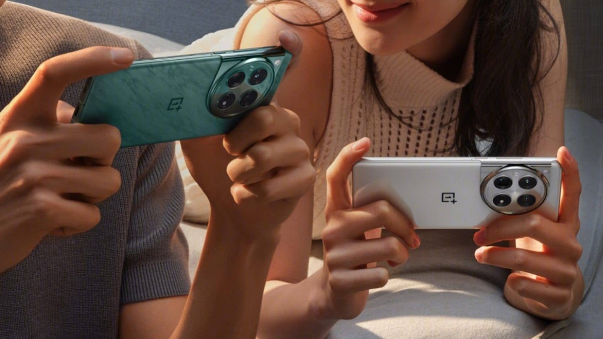 Deux exemplaires du OnePlus 12 tenus par deux personnes dans leurs mains, l'un dans un coloris bleu, l'autre dans un coloris blanc