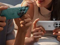 Deux exemplaires du OnePlus 12 tenus par deux personnes dans leurs mains, l'un dans un coloris bleu, l'autre dans un coloris blanc
