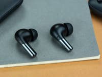 Les deux OnePlus Buds Pro 2 posés sur une feuille Canson verte foncée