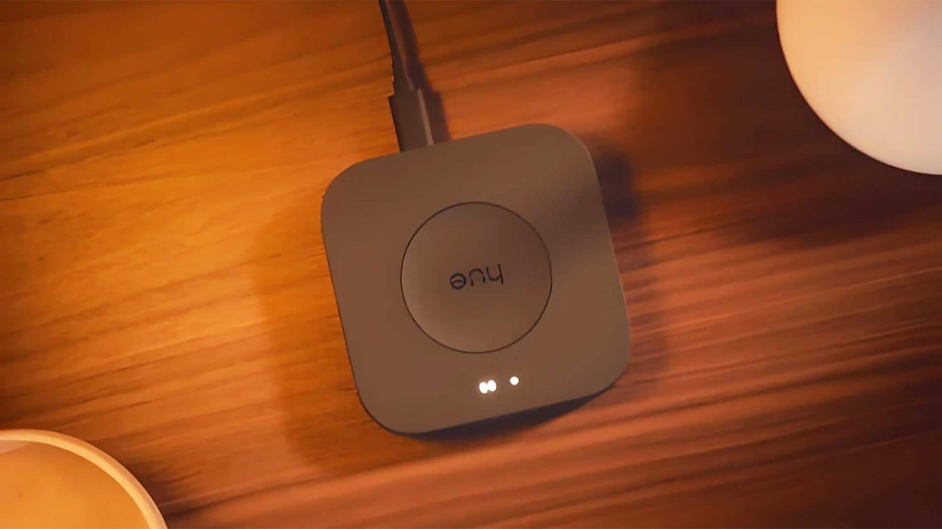 Un hub de éclairage intelligent Philips Hue sur une surface en bois.