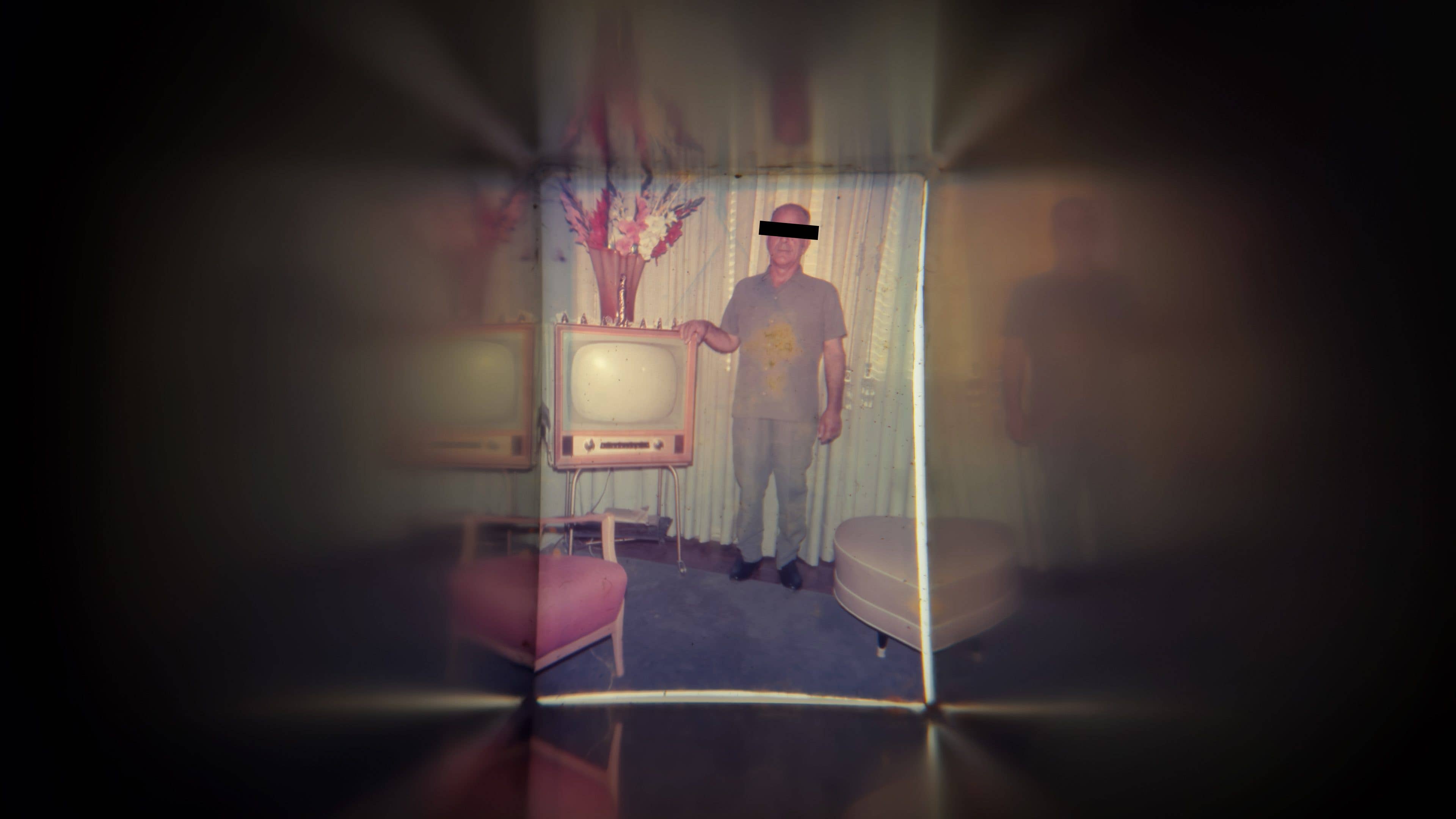 Un homme debout à côté d'un vieux téléviseur des années 50