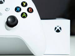 Un contrôleur Xbox blanc avec des boutons colorés à côté d'une boîte Xbox.