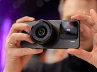 Une personne tenant un smartphone Xiaomi 15 Concept avec un grand objectif.