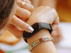 Une personne vérifie un bracelet de fitness noir à son poignet.