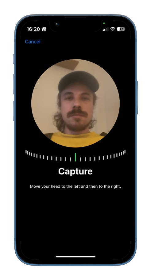 Un écran de téléphone affichant un processus de capture avec des instructions pour bouger la tête à gauche et à droite.