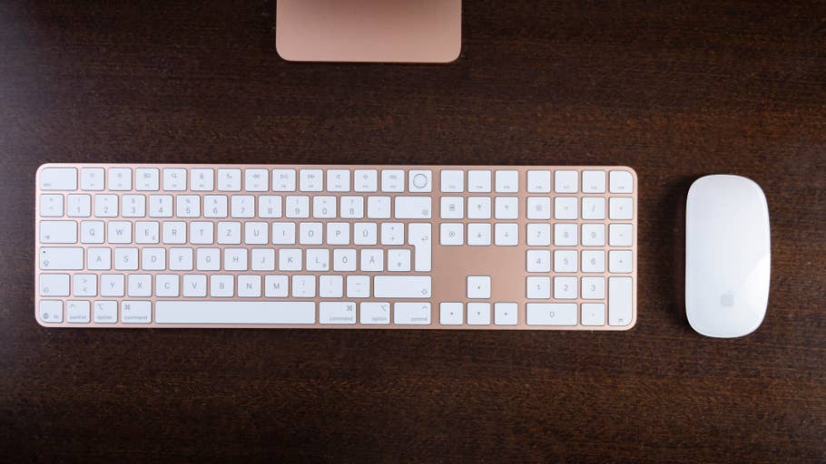 Clavier et souris Apple sur une surface en bois, avec un design épuré et des touches blanches.