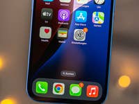 Gros plan de l'écran d'un Apple iPhone 16 affichant diverses icônes d'applications.