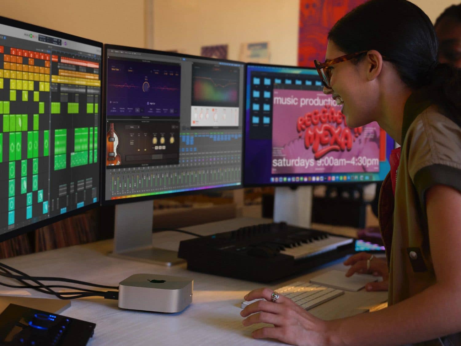 Une personne travaille dans un studio de musique avec un Apple Mac Mini et plusieurs écrans affichant des logiciels de musique.