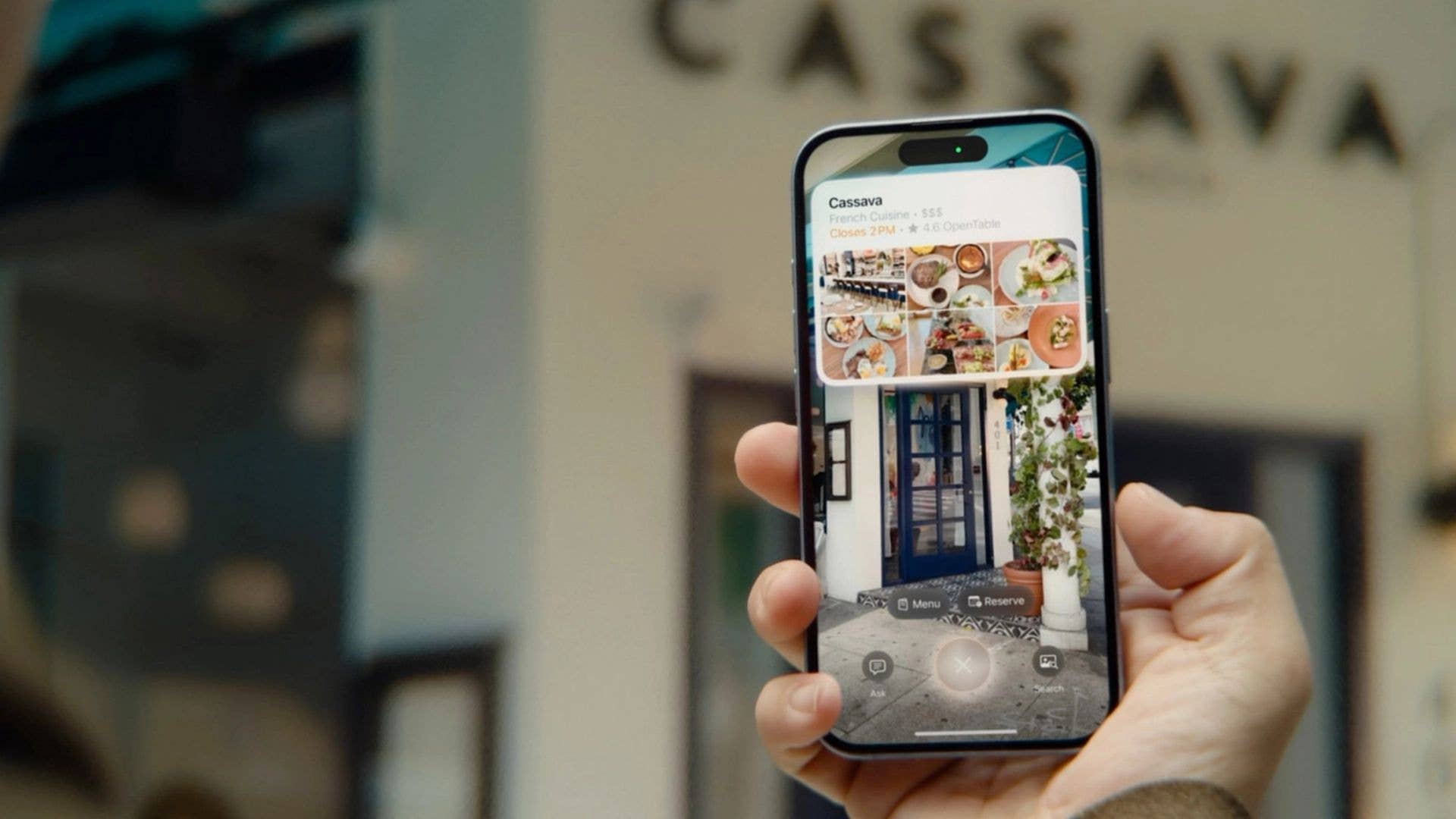 Une personne tenant un smartphone affichant un restaurant nommé 'Cassava' avec des images de plats et des détails en réalité augmentée.