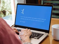 Un ordinateur portable affiche un message d'erreur sur un écran bleu : 'Votre PC a rencontré un problème et doit redémarrer. 9% complet.'