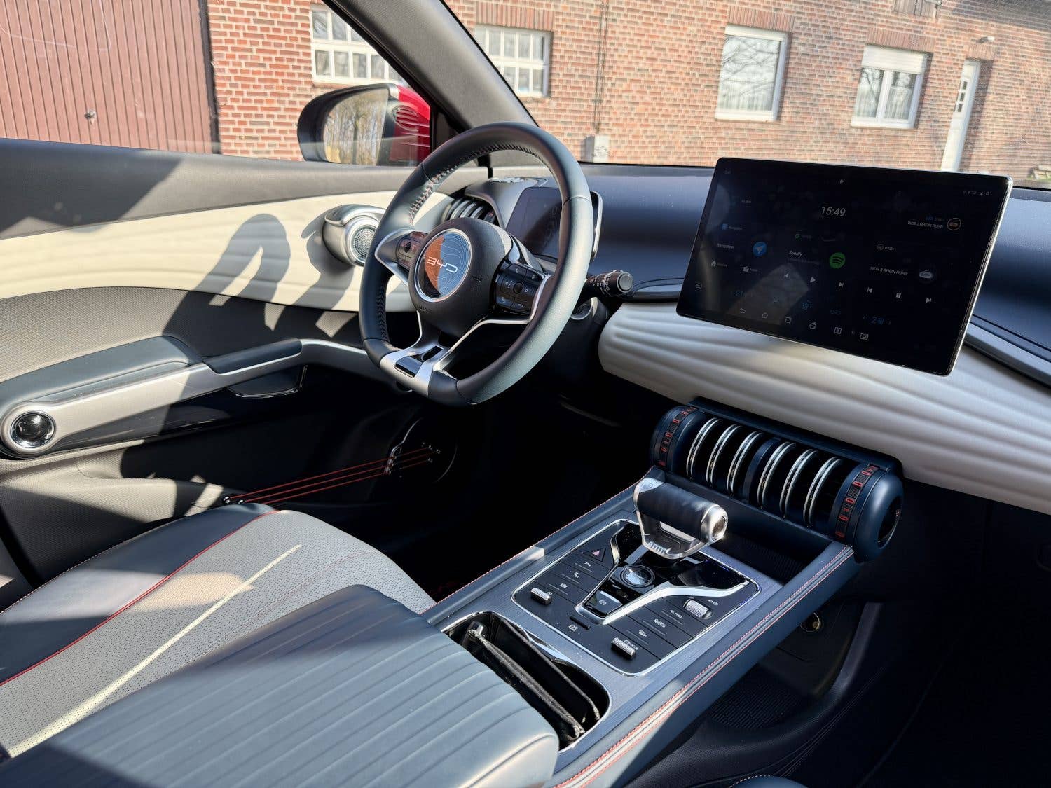 Vue intérieure d'une BYD Atto 3, montrant le tableau de bord, le volant et l'écran d'infodivertissement.