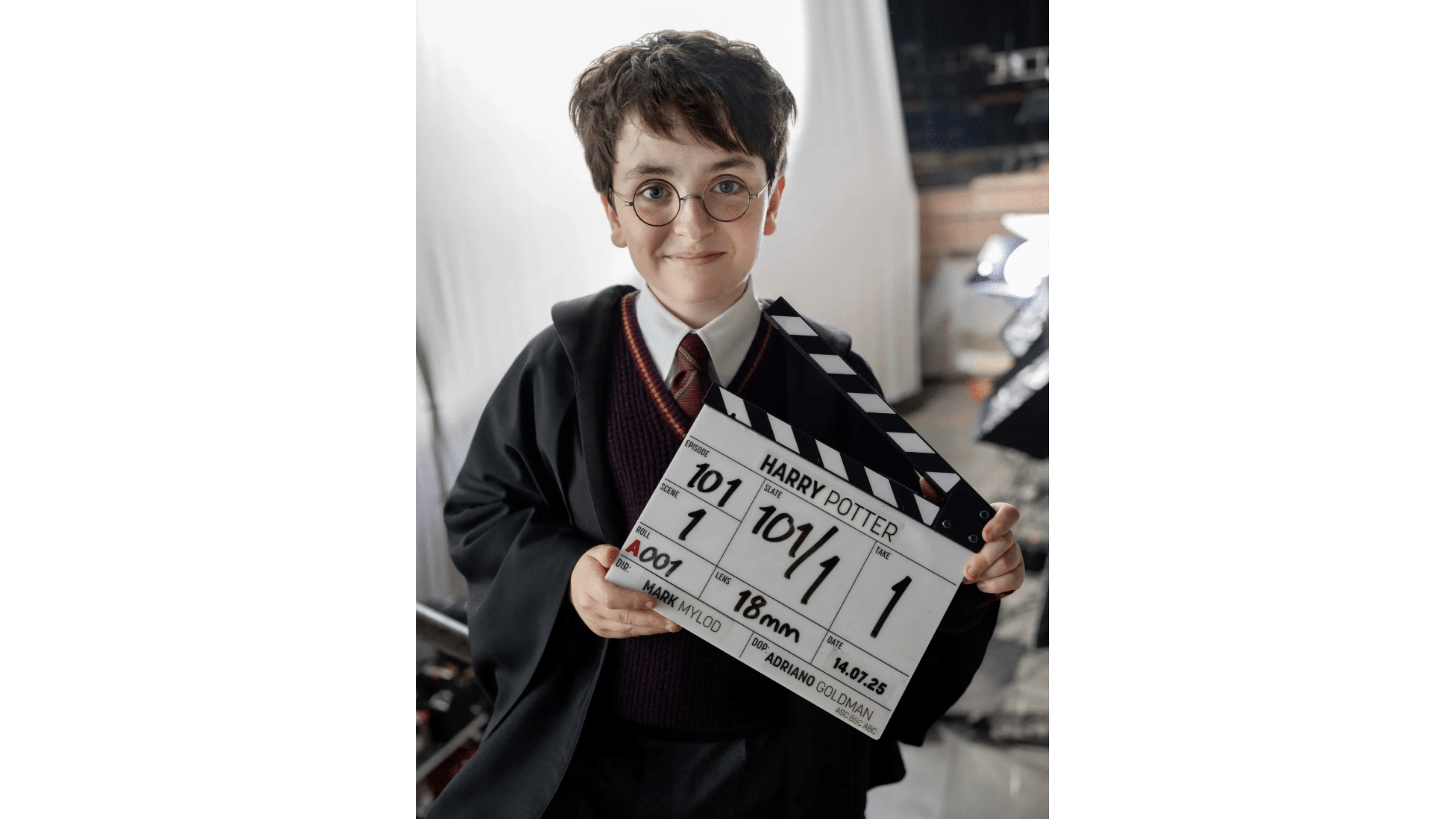 Un jeune acteur tenant un clap de cinéma avec l'inscription 'HARRY POTTER' sur le plateau.