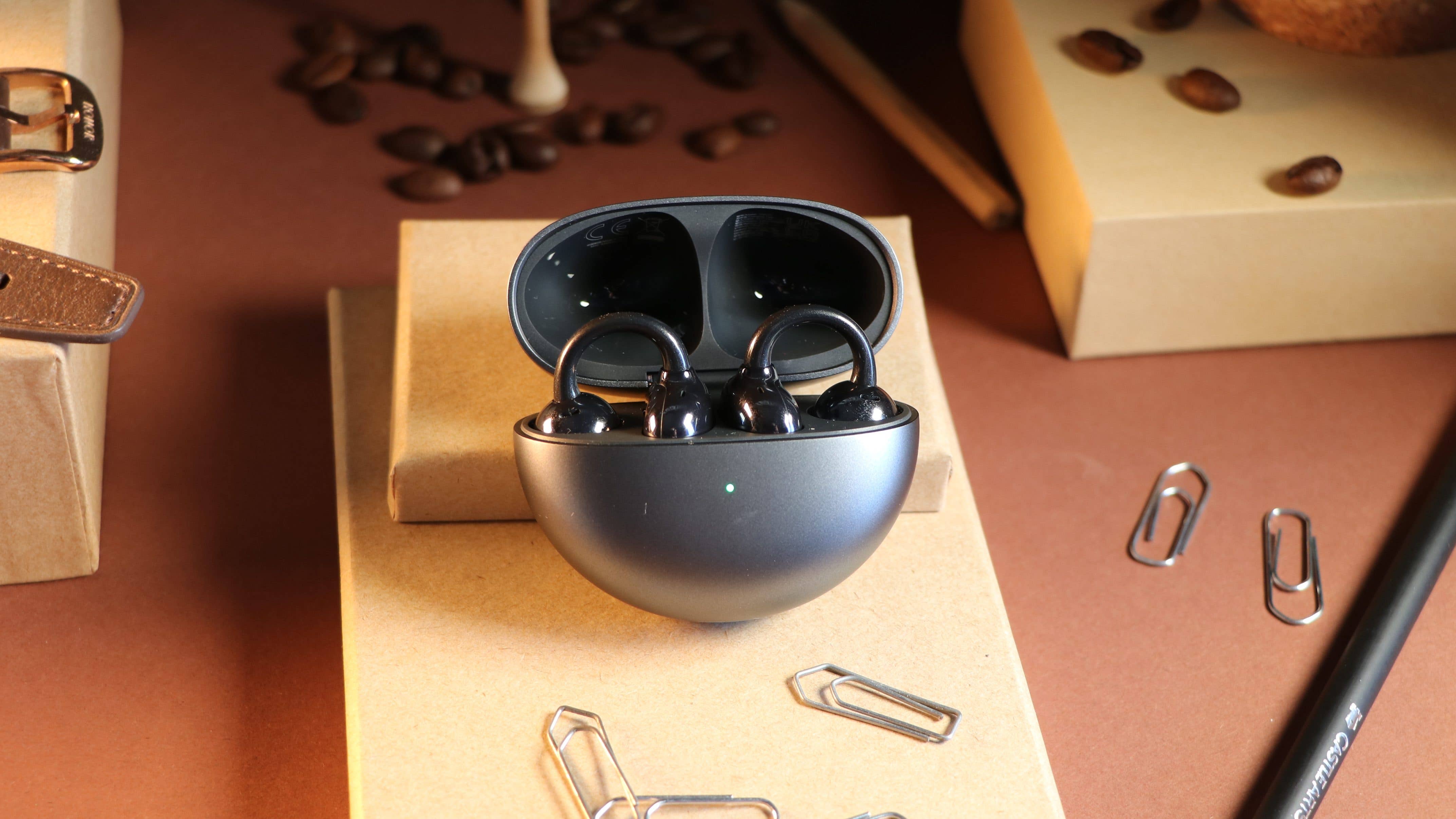 Les Huawei FreeClip vus de face et rangés dans le boîtier dont le couvercle est partiellement ouvert