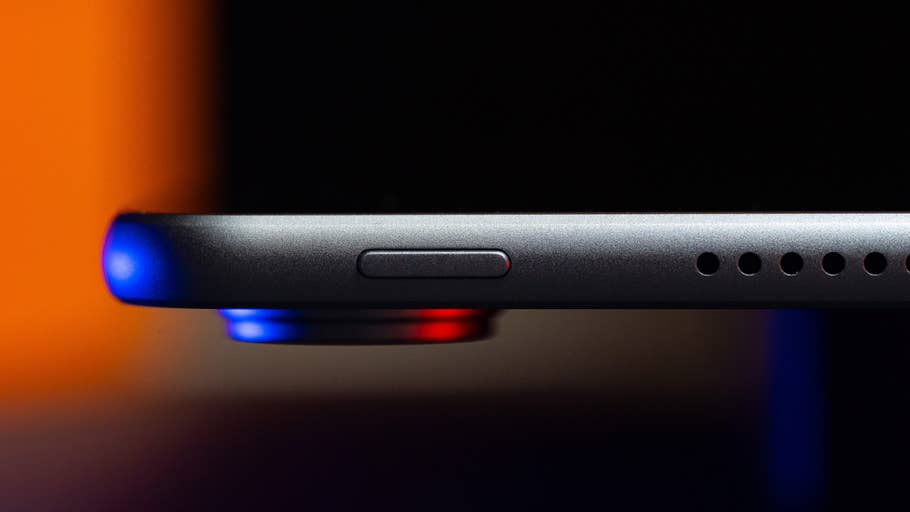 Gros plan du bord du0027un Huawei MatePad Air, avec un bouton et des trous de haut-parleur, illuminé en bleu et rouge.