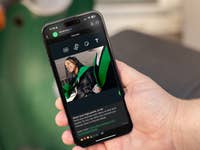 Une personne tenant un Apple iPhone 15 Pro Max affichant un chat WhatsApp avec une image.