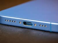 Gros plan d'un Apple iPhone 16 montrant le port de charge et les trous de haut-parleur.