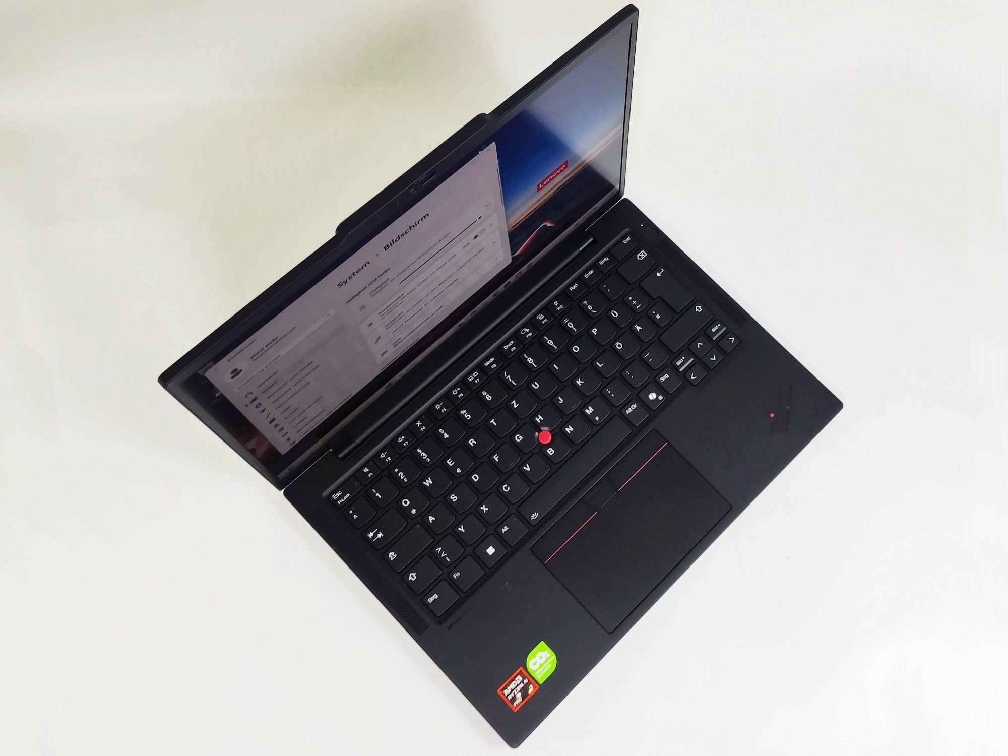 Un ordinateur portable Lenovo ThinkPad T14s Gen6 ouvert, affichant le clavier et l'écran avec des informations système.