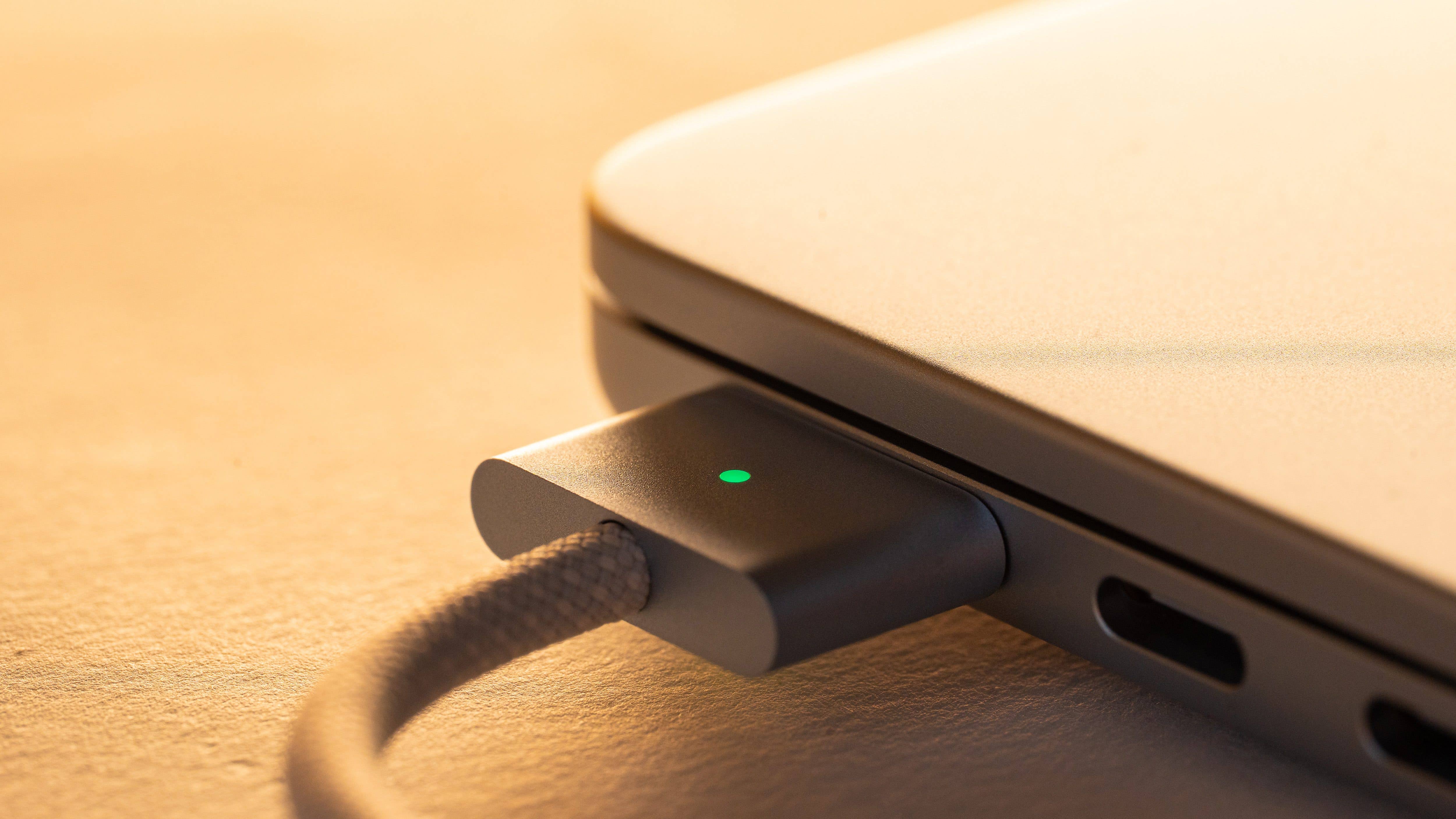 Gros plan sur le port de charge d'un MacBook Air M4 avec un indicateur lumineux vert.