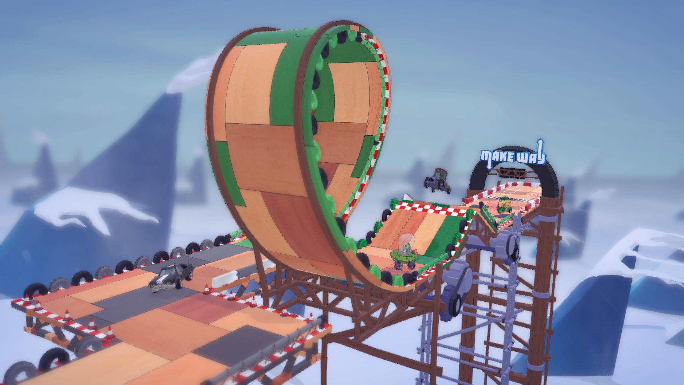 Un circuit de course avec une boucle, comportant des voitures miniatures et un panneau indiquant 'MAKE WAY'.