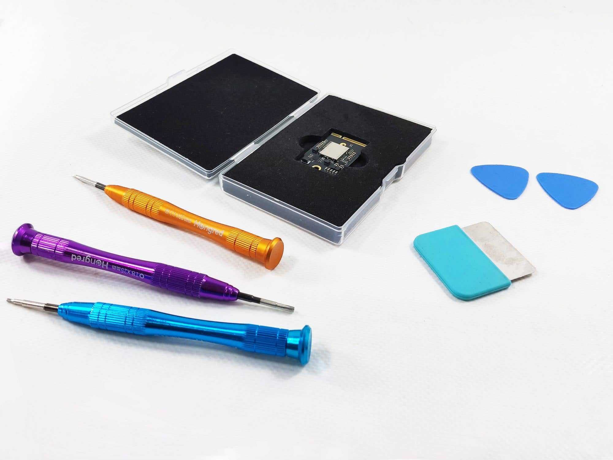 Outils et un kit d'extension de mémoire pour Apple Mac Mini M4 sur une surface blanche.