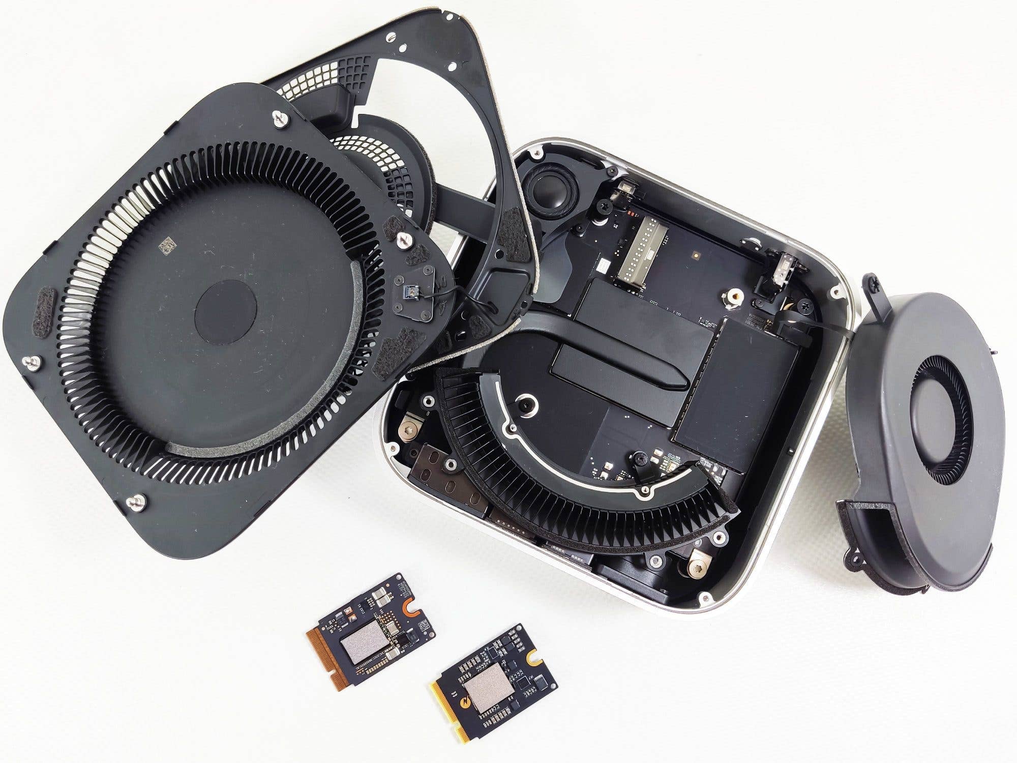 Un Apple Mac Mini M4 ouvert montrant des composants internes et deux modules d'extension de mémoire.