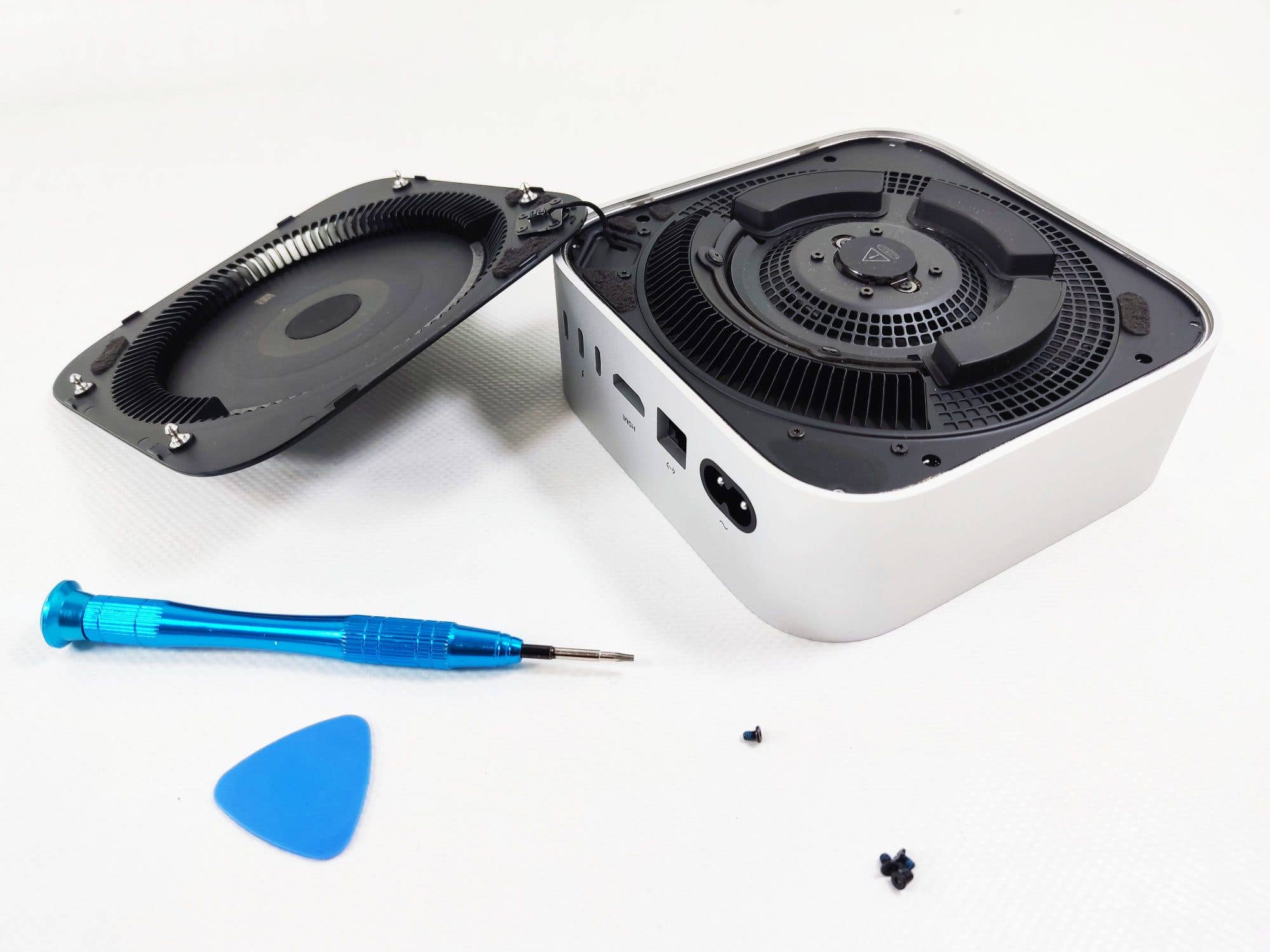 Apple Mac Mini M4 avec couvercle ouvert, tournevis et outil pour l'expansion de la mémoire.