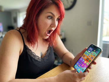 Une femme regarde avec étonnement son téléphone portable, où de nombreuses applications gratuites sont proposées.