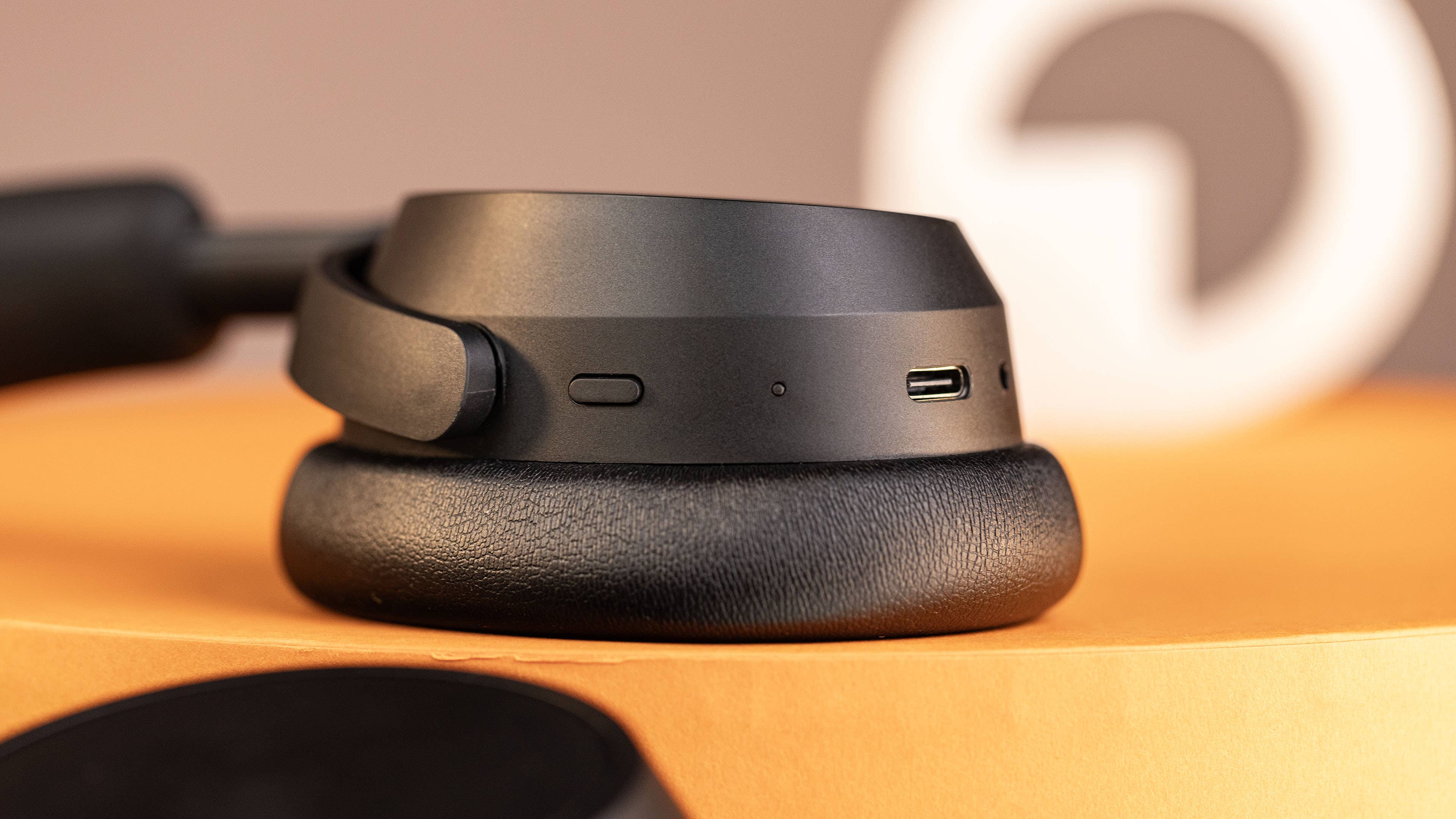 Le casque sans fil Sennheiser Accentum Plus Wireless posé à plat sur une table avec un zoom sur son oreillette droite