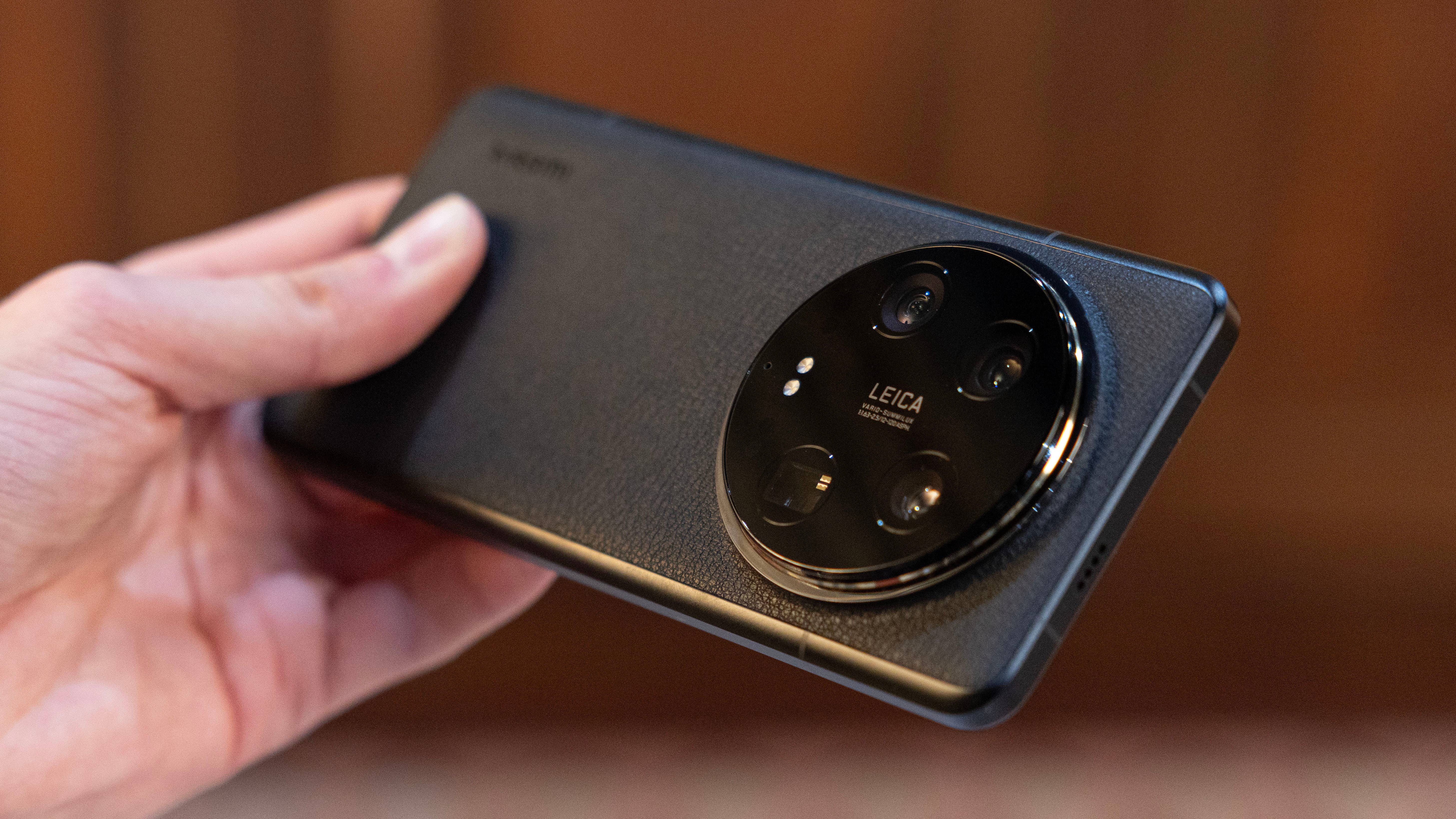 Le Xiaomi 14 Ultra vu de dos et tenu horizontalement dans une main gauche